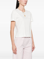 Woman wearing a white top and light pink pants on a white background