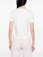 Person wearing a white t-shirt and light pink pants on a white background