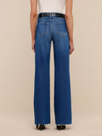 Blue jeans worn by a person on a beige background