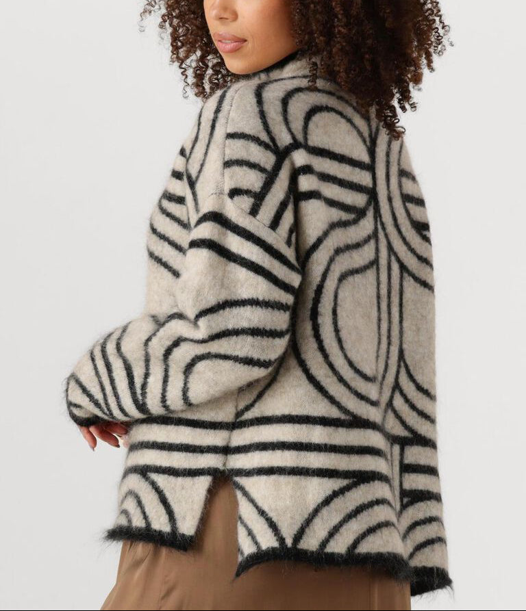 Woman wearing a patterned sweater on a white background