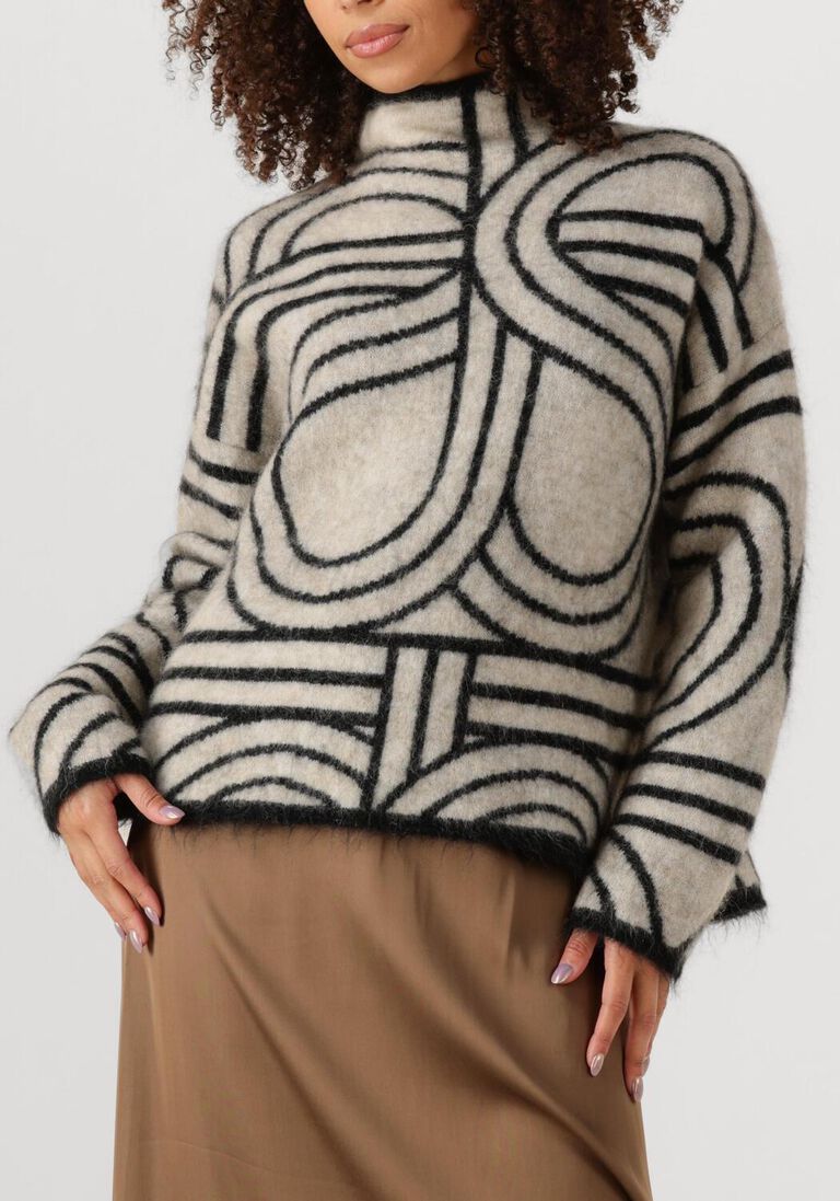 Person wearing a patterned sweater with a plain background