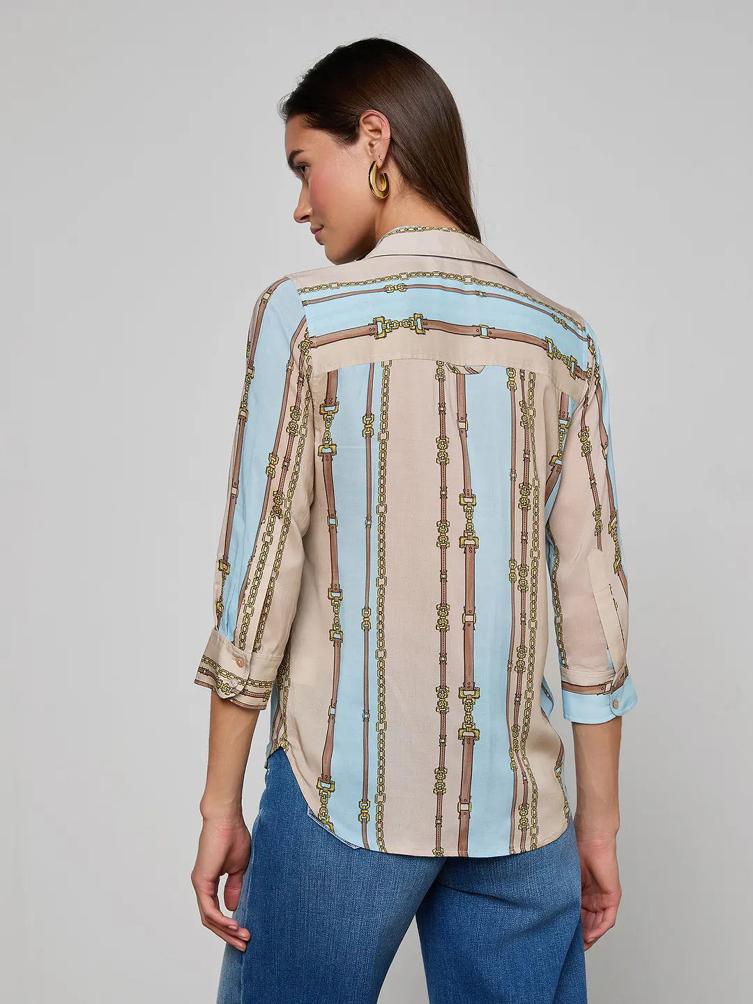Woman wearing a patterned shirt with a gray background