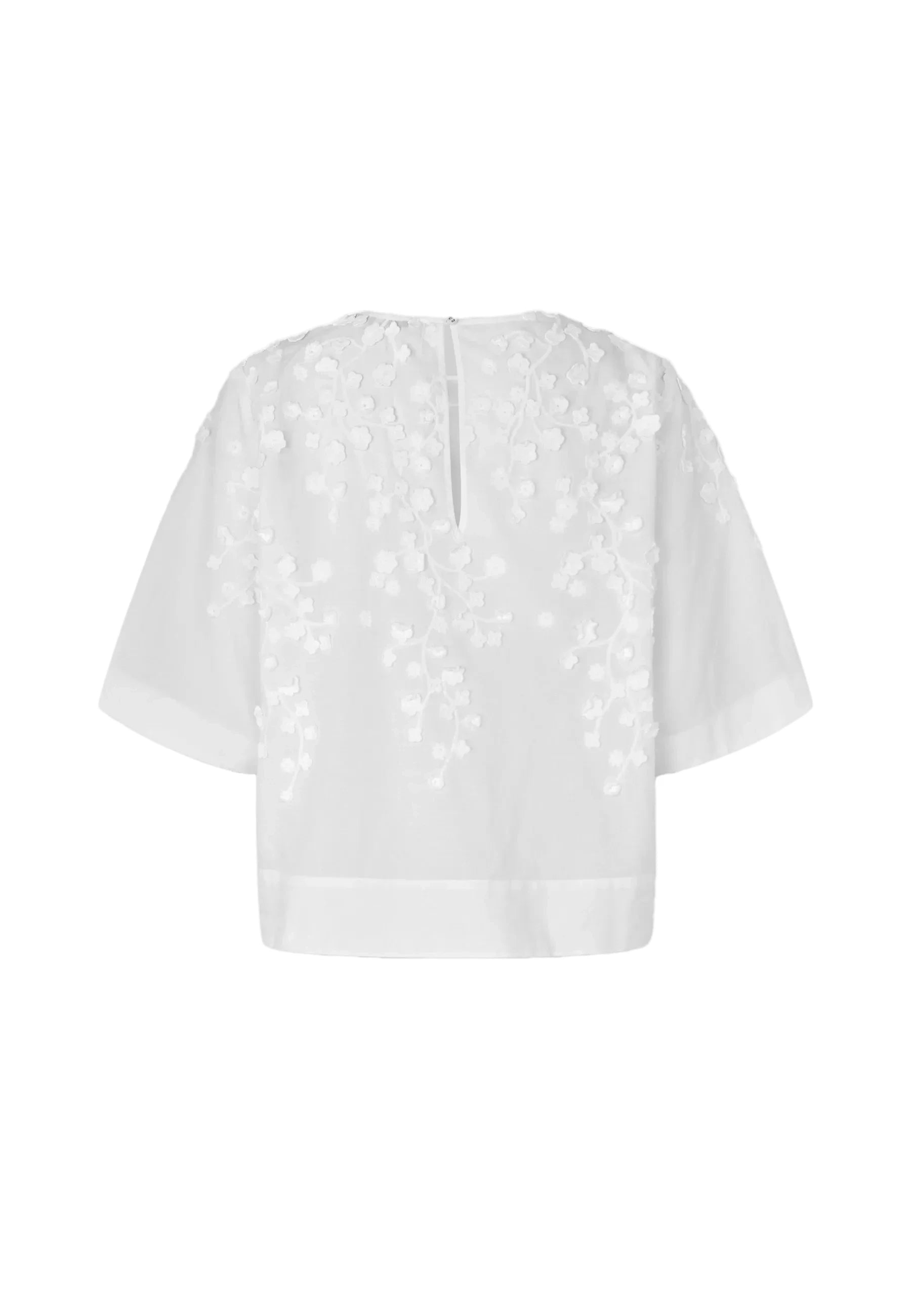 White short-sleeve blouse with floral applique embroidery on the back, shown against a plain white background.