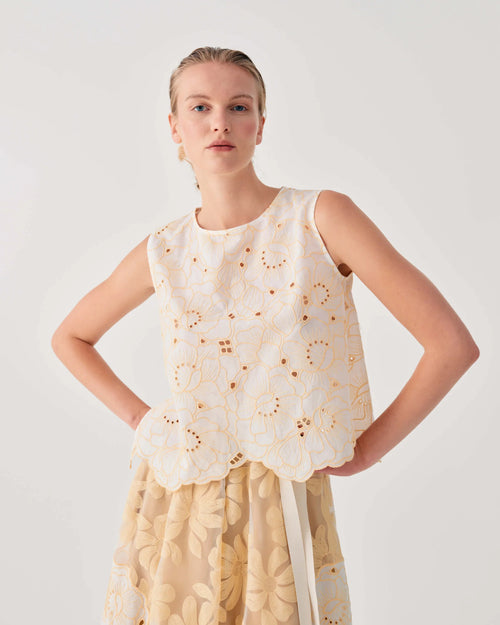 Woman wearing a sleeveless top with a tortilla pattern on a plain background