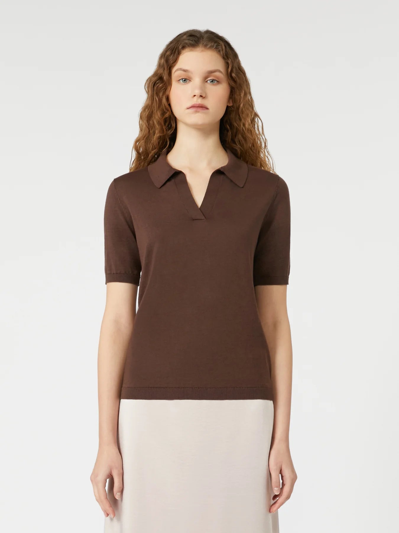 Woman wearing a brown polo shirt against a white background