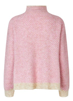 Pink textured sweater on a gray background