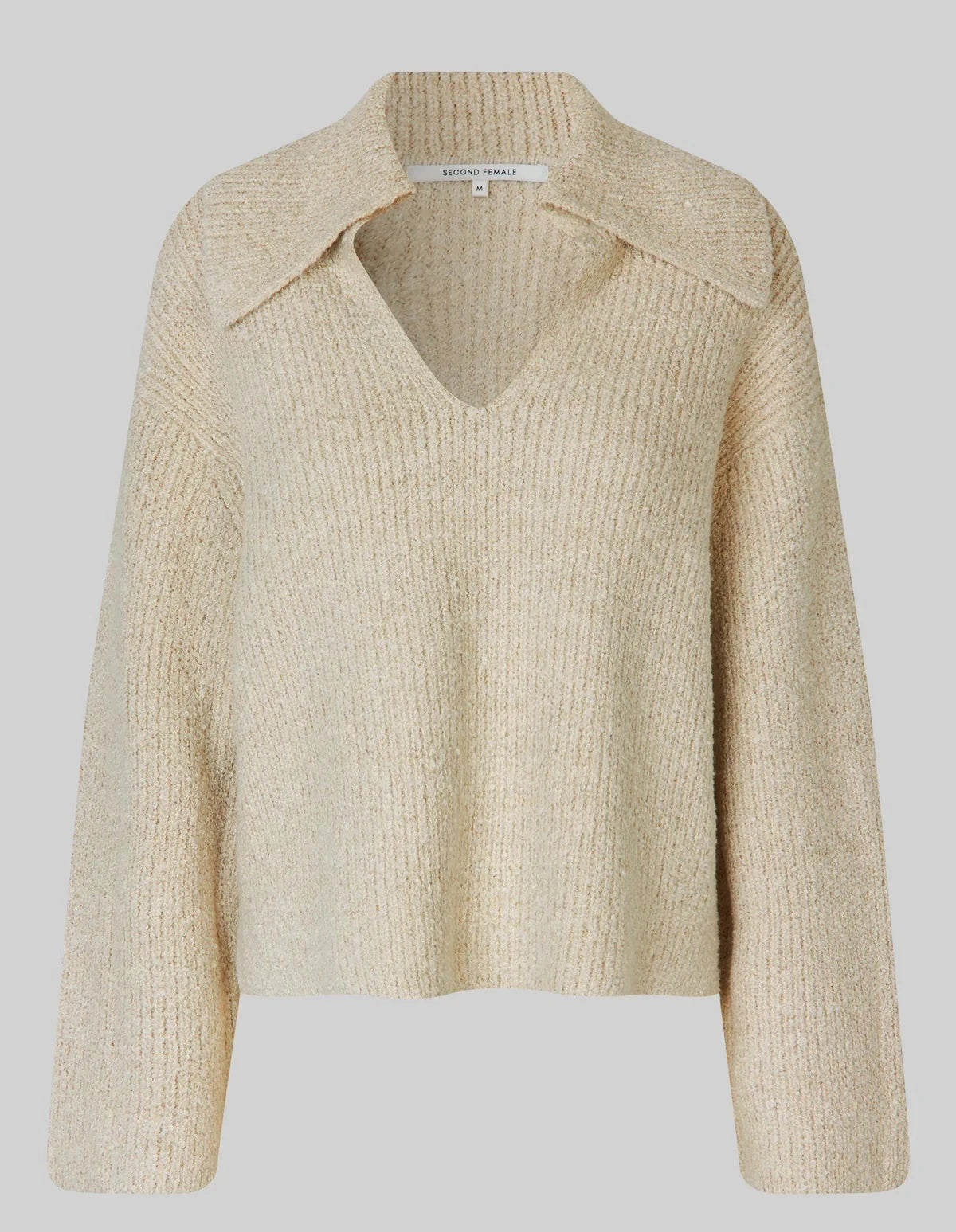 Beige knitted sweater on a light gray background