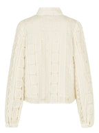 Cream-colored blouse with long sleeves on a gray background