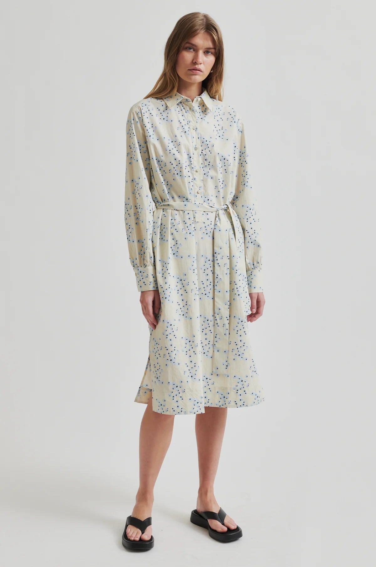 Woman wearing a second female floral dress on a white background