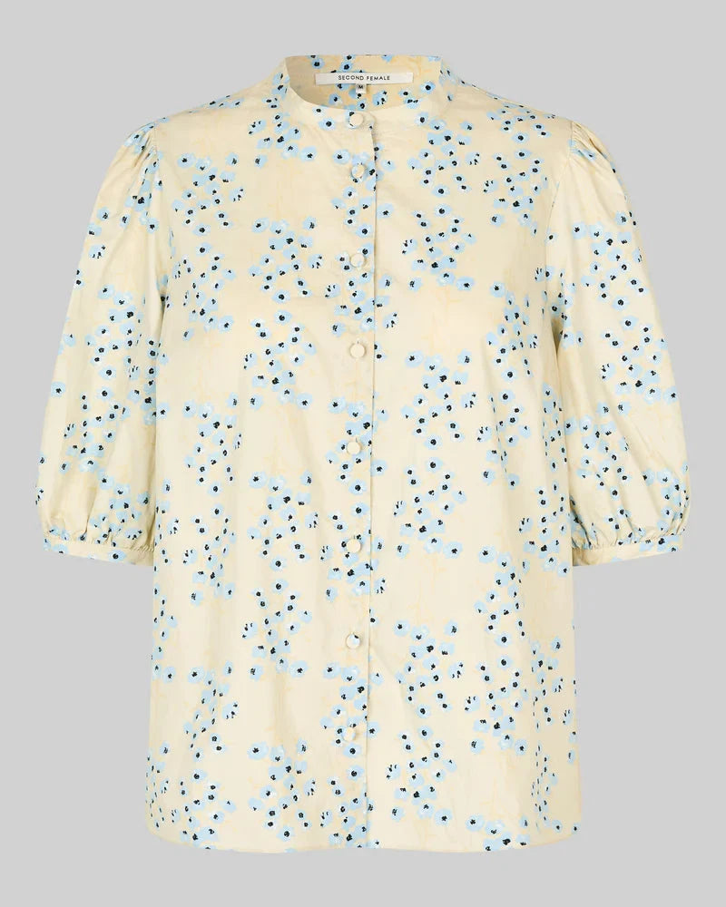 Beige blouse with blue floral pattern on a gray background