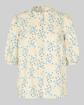 Beige blouse with blue floral pattern on a gray background