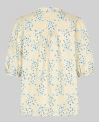 Beige blouse with blue floral pattern on a gray background