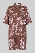 Brown dress with white floral pattern on a gray background