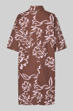 Brown dress with white floral pattern on a gray background