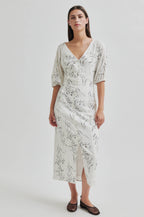 Woman wearing a floral dress on a plain background