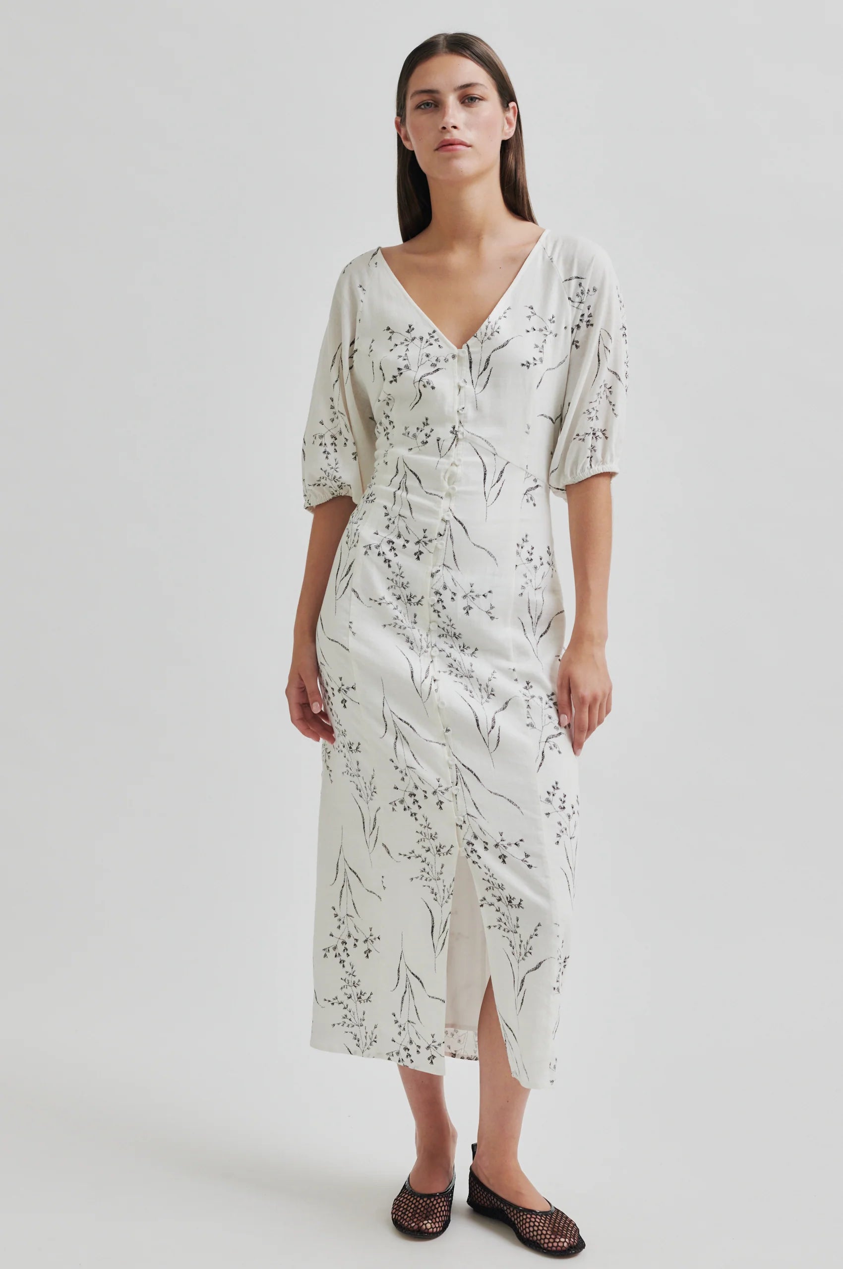 Woman wearing a floral dress on a plain background