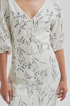 White dress with black floral pattern on a white background