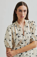 Woman wearing a floral dress against a plain background