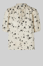Floral blouse with puff sleeves on a light gray background