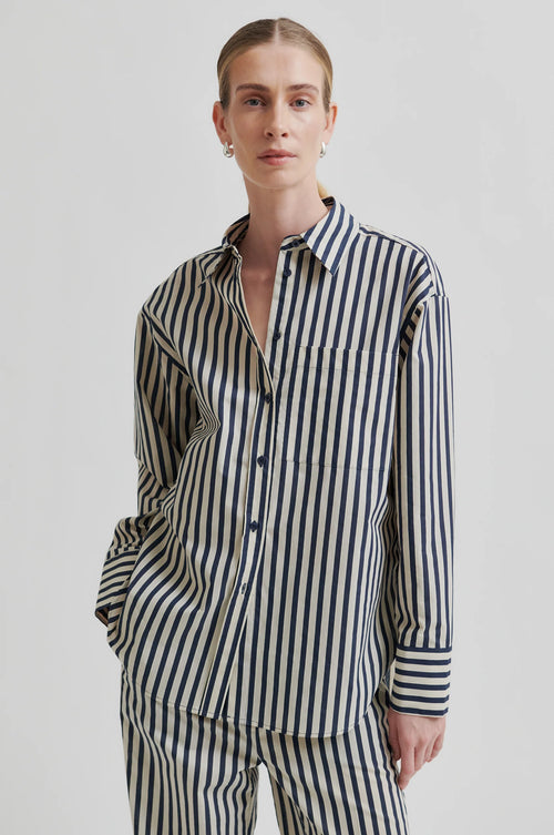 Person wearing a black and white striped shirt and pants on a plain background