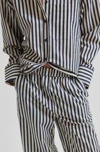 Person wearing a striped shirt and pants on a white background