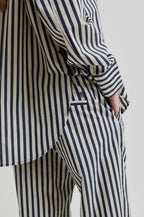 Person wearing a striped shirt and pants on a plain background