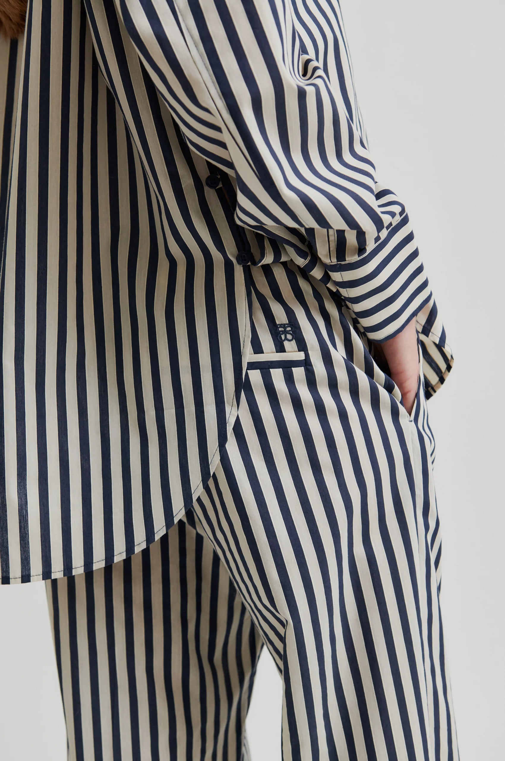 Person wearing a striped shirt and pants on a plain background