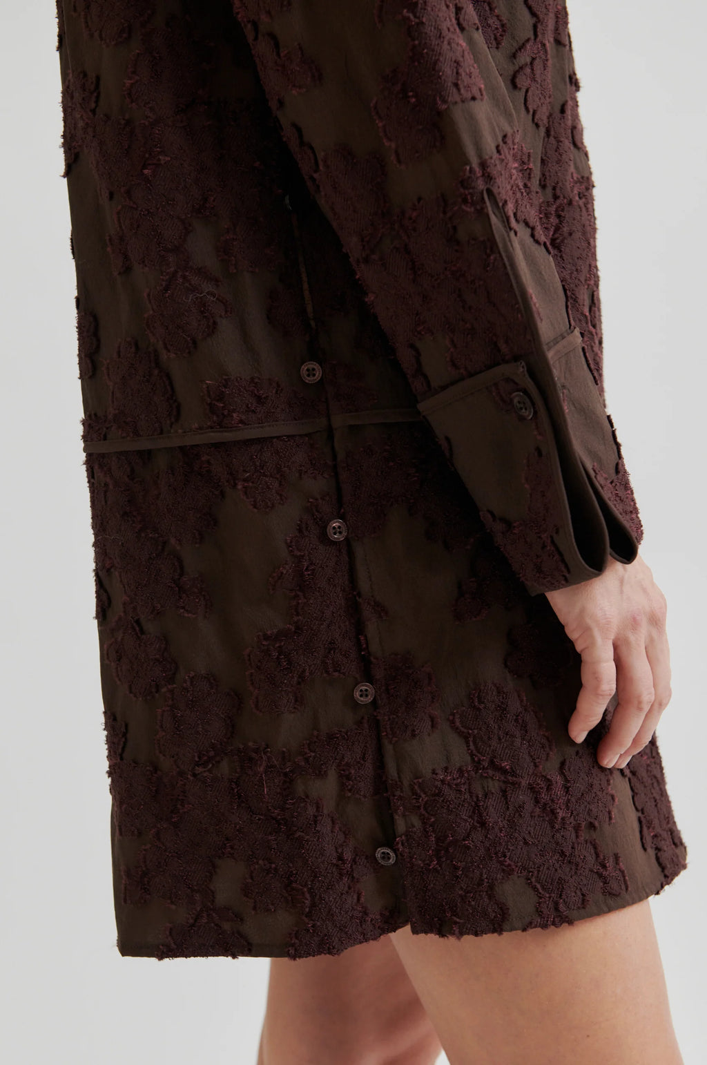 Brown textured dress worn by a person on a white background