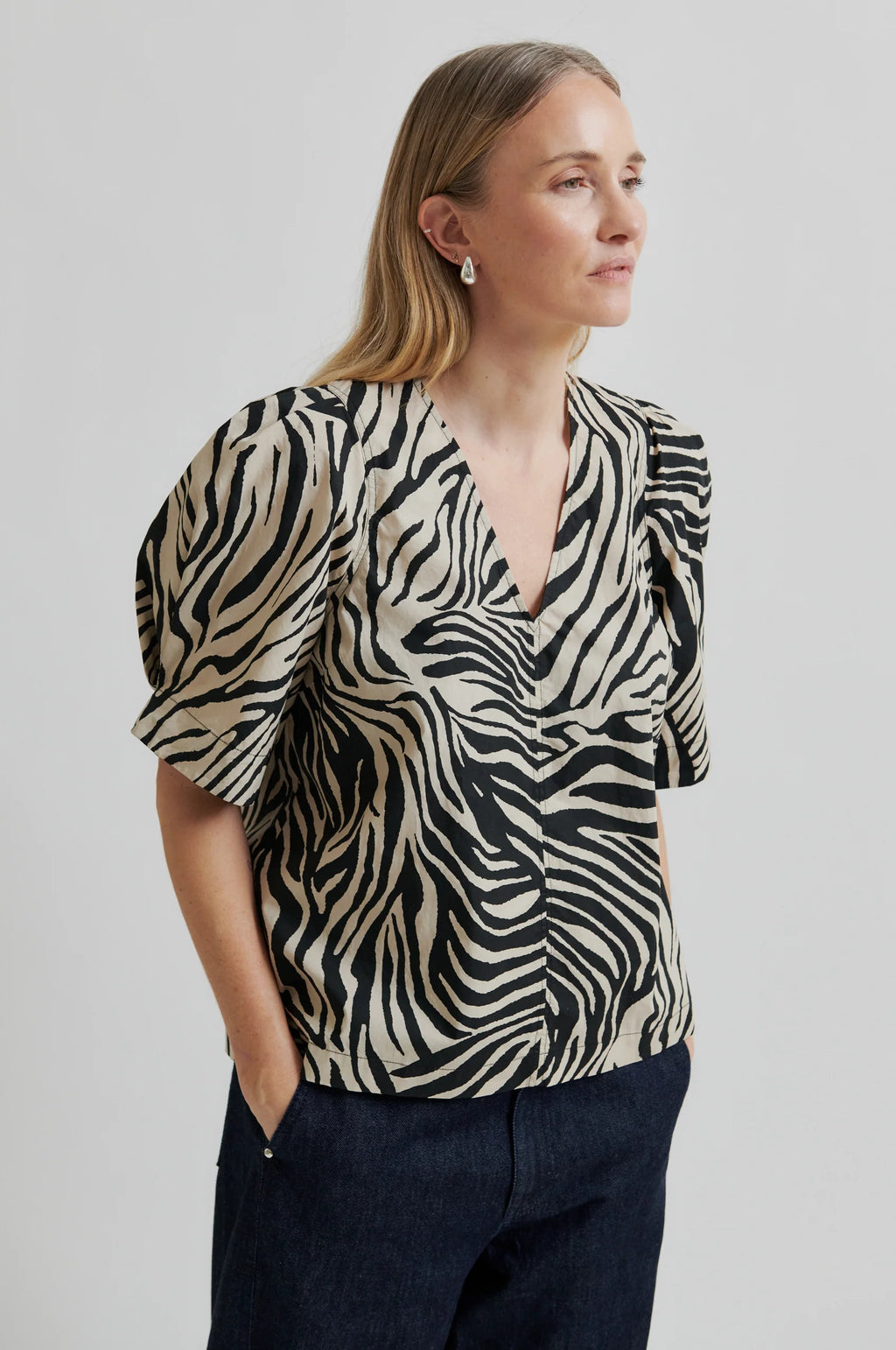 Woman wearing a zebra print blouse against a plain background