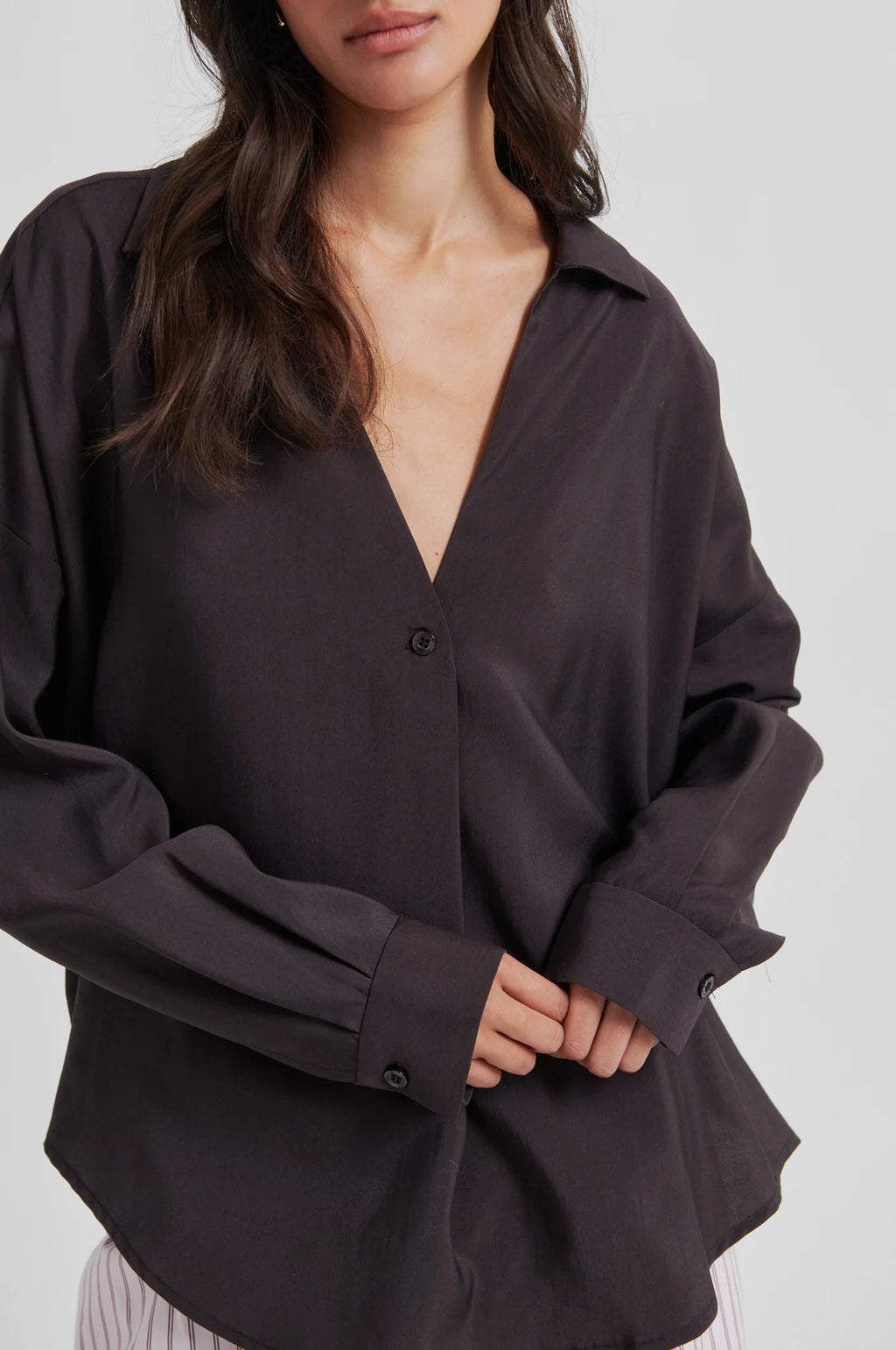 Black button-up shirt worn by a person on a white background
