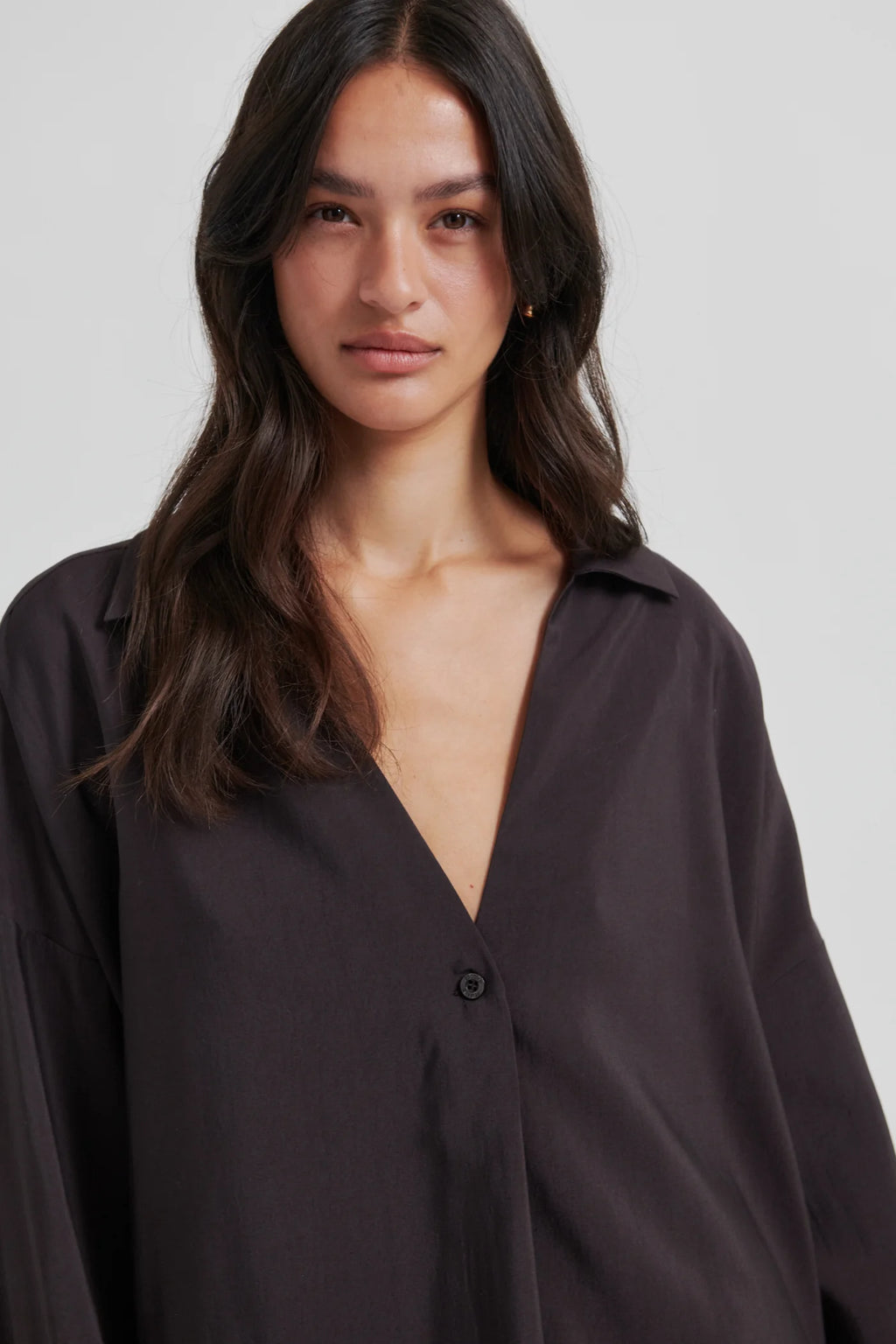 Woman wearing a black shirt against a plain background