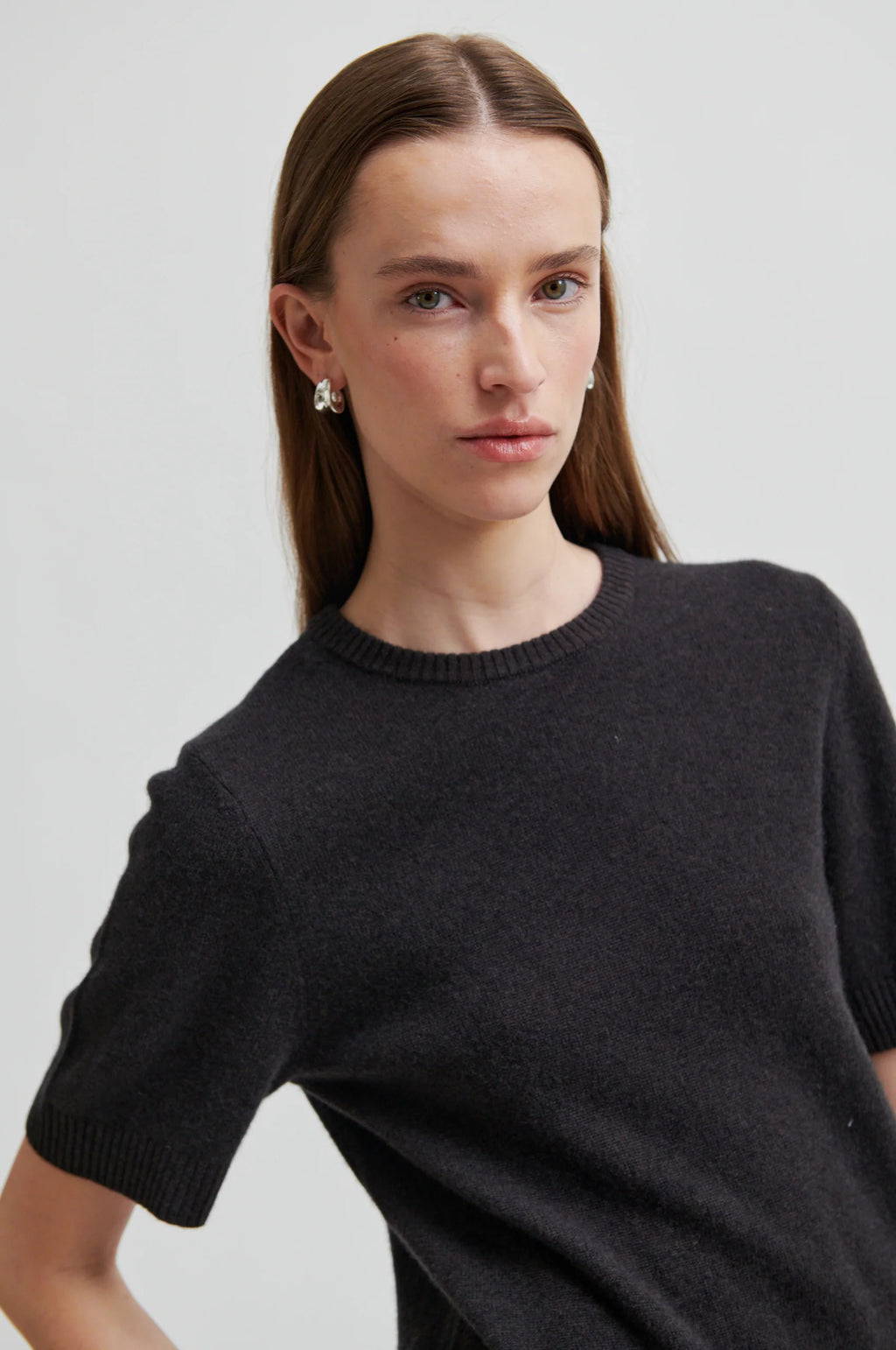 Woman wearing a black sweater against a plain background