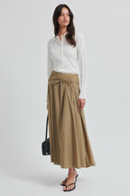 Woman wearing a white blouse and beige skirt on a white background