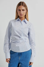 Woman wearing a light blue shirt and blue jeans on a white background