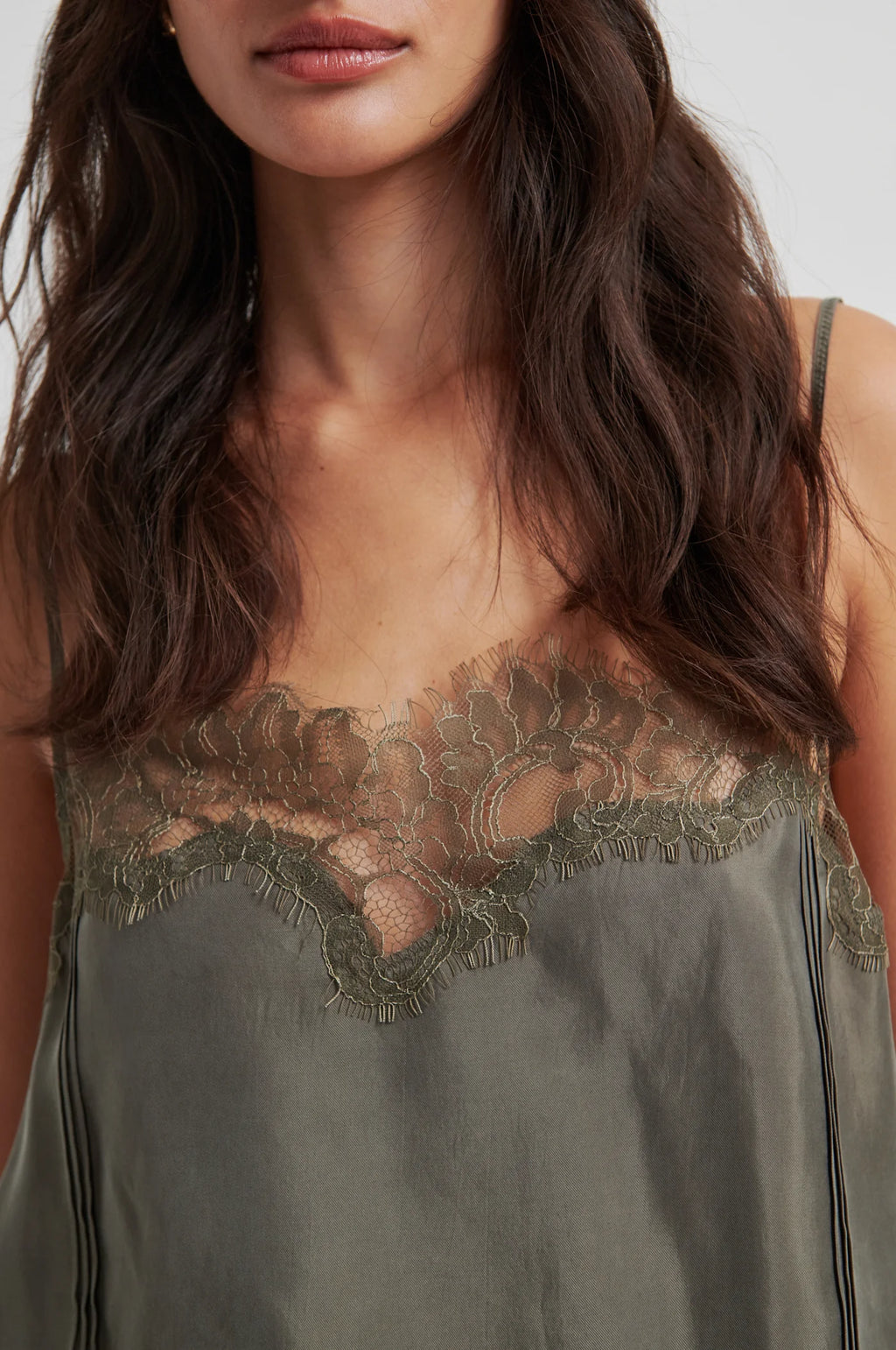 Woman wearing a green slip dress with lace detailing