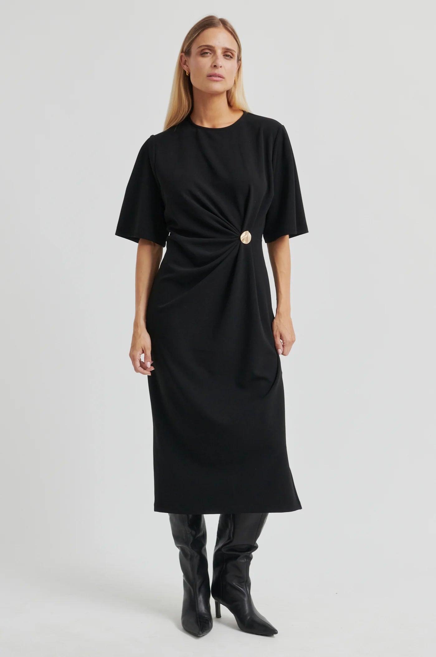 Woman wearing a black dress with a belt on a white background