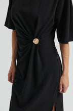 Black dress with a knot detail on a white background