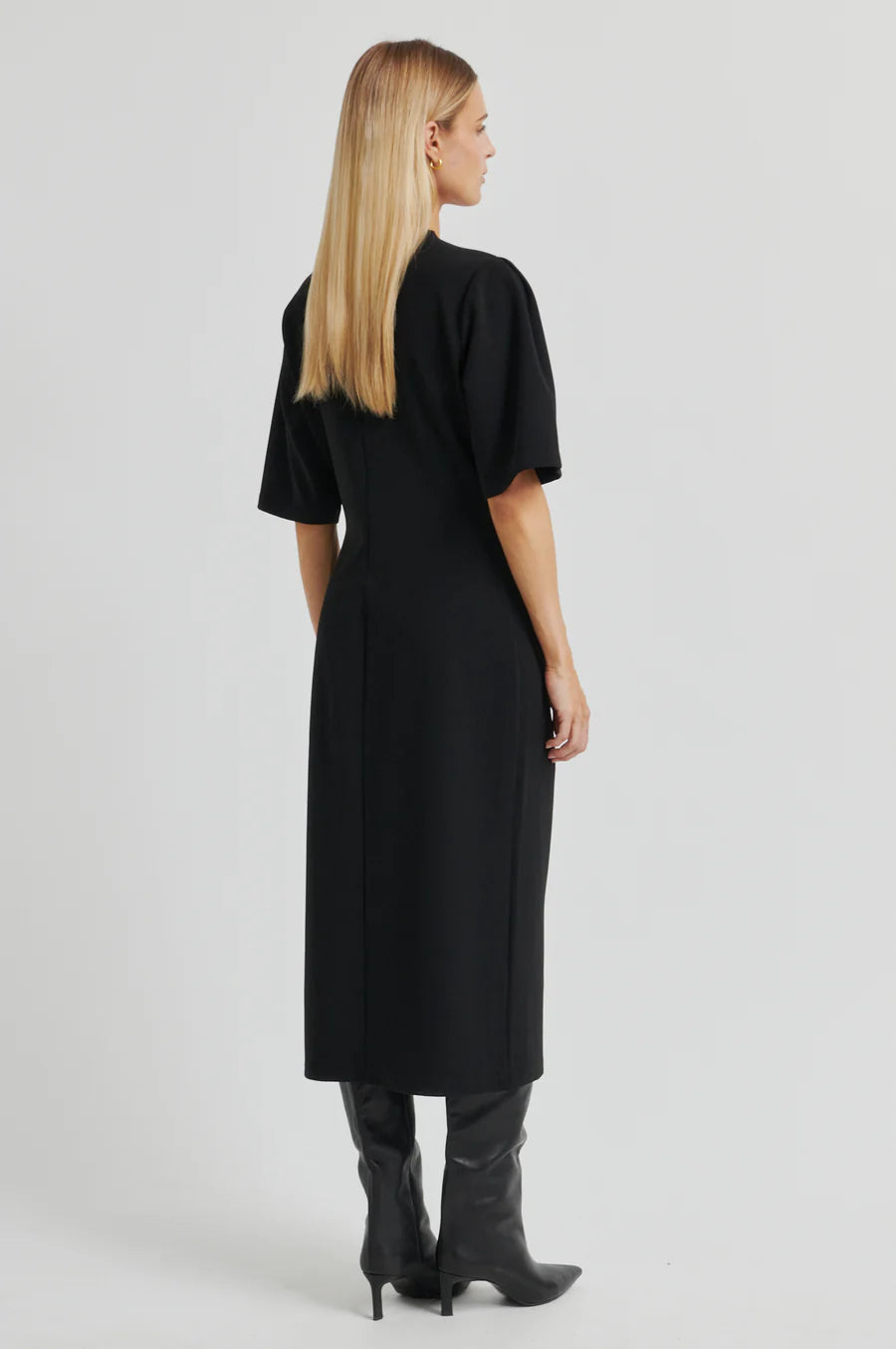 Woman wearing a black dress with short sleeves on a white background