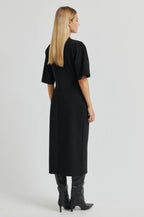 Woman wearing a black dress with short sleeves on a white background