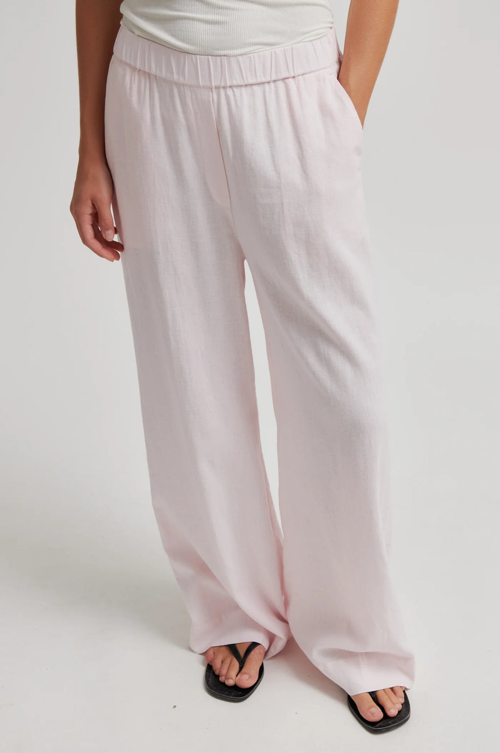 Light pink wide-leg pants worn by a person on a white background
