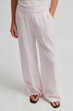 Light pink wide-leg pants worn by a person on a white background
