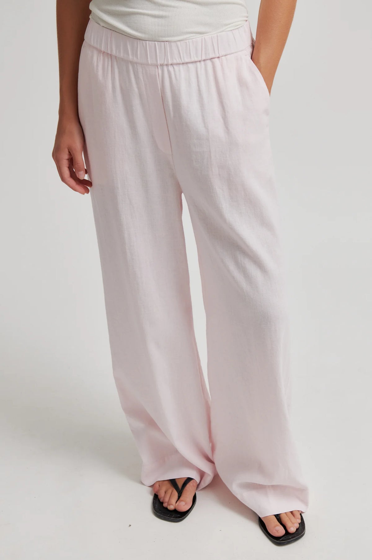 Light pink wide-leg pants worn by a person on a white background