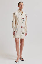 Woman wearing a floral dress on a plain background