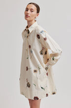 Woman wearing a floral dress on a plain background