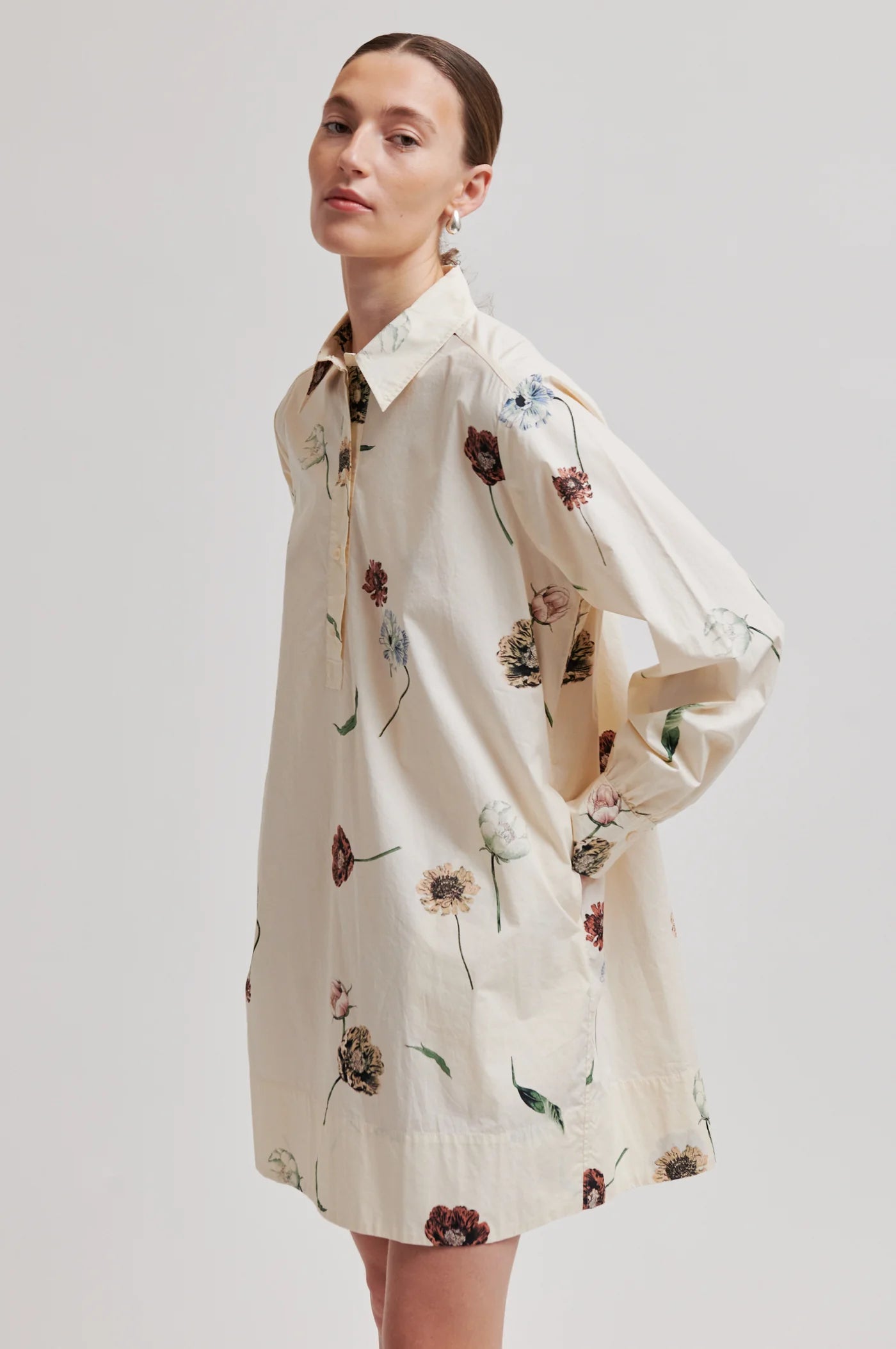 Woman wearing a floral dress on a plain background