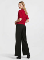 Woman wearing a red top and black pants on a white background