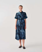 Woman wearing a blue tie-dye dress on a white background