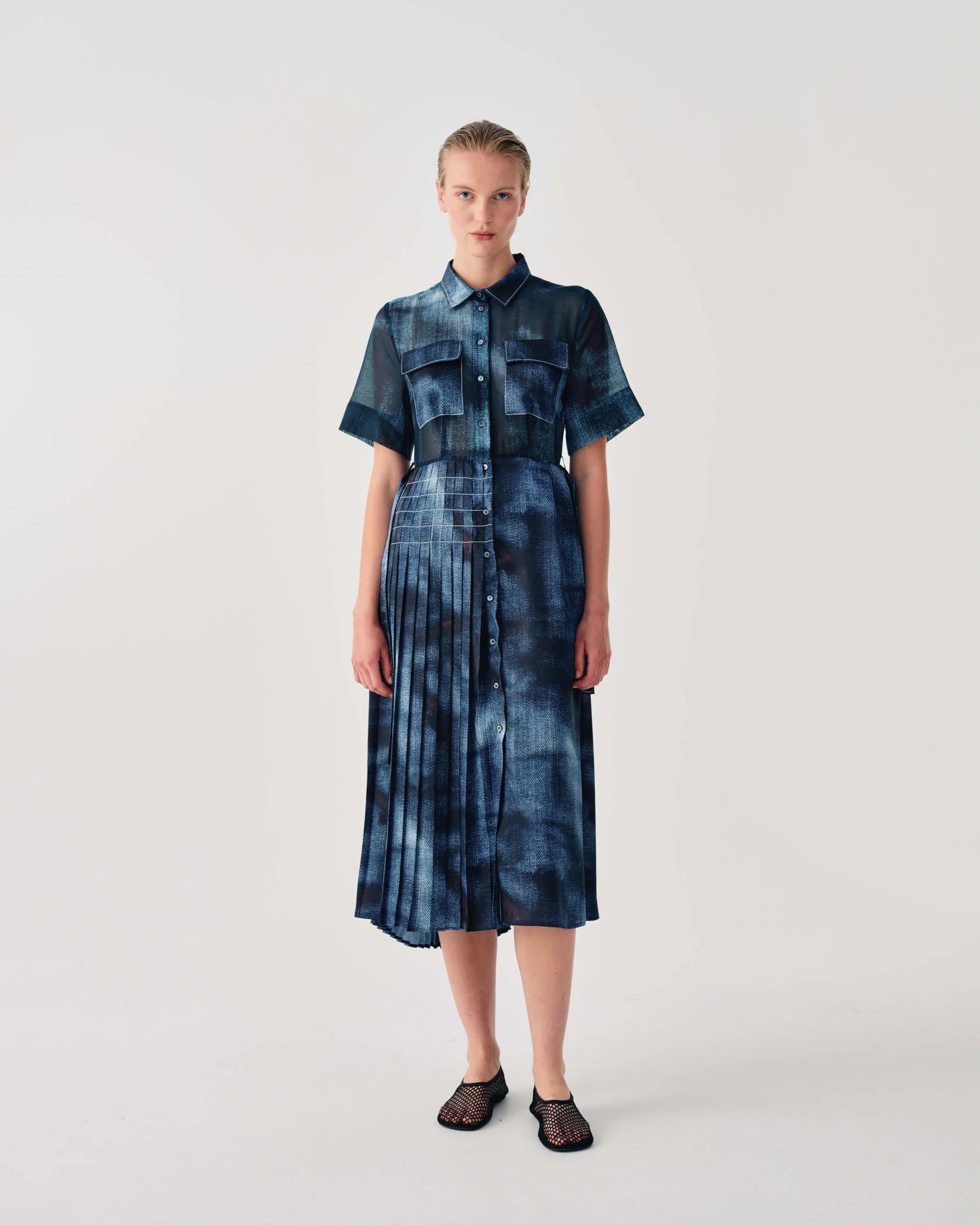 Woman wearing a blue tie-dye dress on a white background