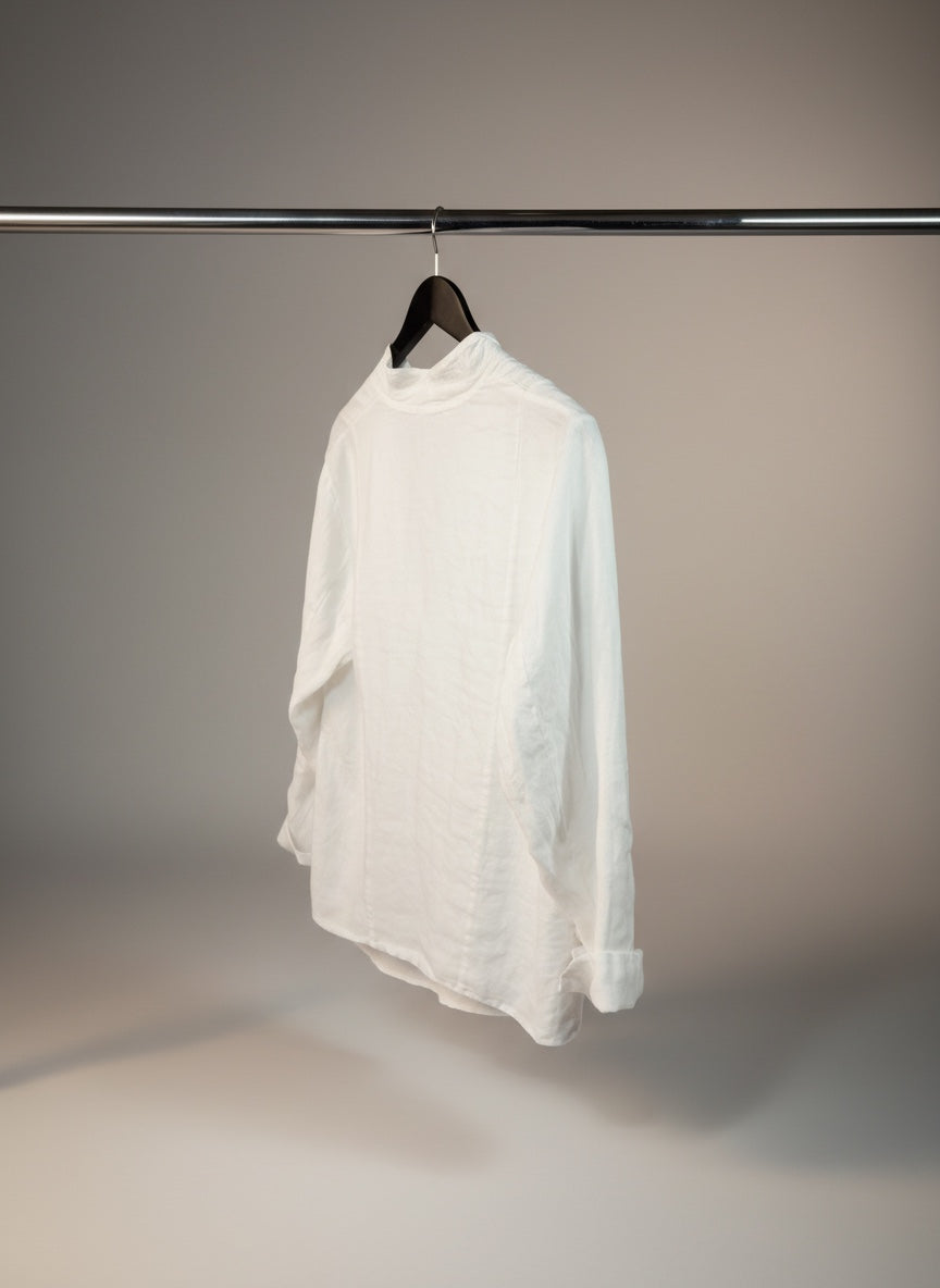 White shirt hanging on a rack against a neutral background