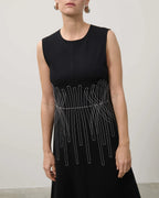 Black sleeveless dress with white geometric pattern on a plain background